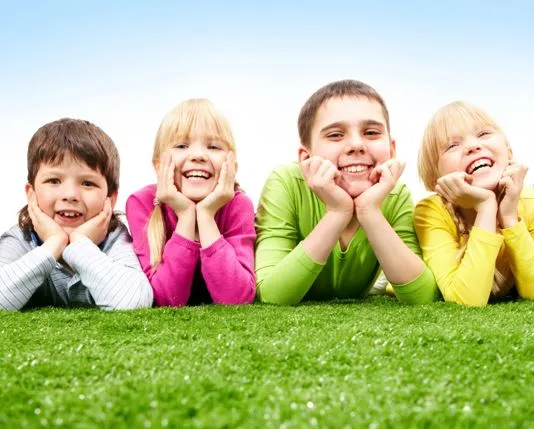 Niños sonriendo en el césped