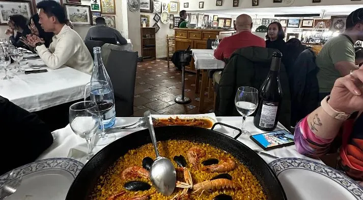 Gente comiendo paella en el restaurante la Riuà de Valencia
