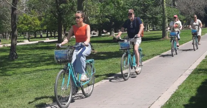 Turistas en bicicleta paseando por el jardín del Turia de Valencia.