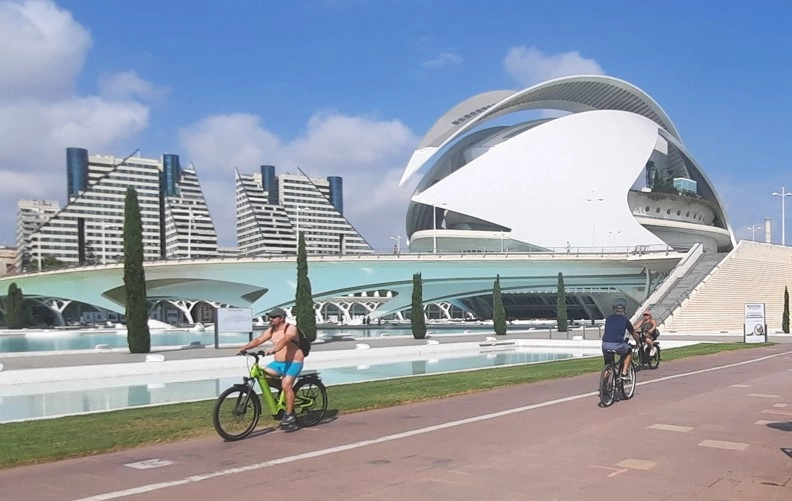 Turistas en bicicleta paseando por la Ciudad de las Artes y las Ciencias de Valencia.