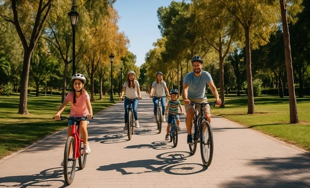 Familia paseando en bicicleta por el Jardín del Turia de Valencia en otoño