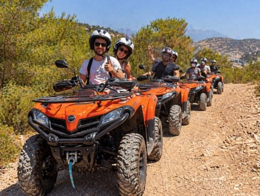 Grupo de personas conduciendo quads por un camino de montaña en Benidorm, disfrutando de una ruta off-road con paisajes naturales y vistas panorámicas.