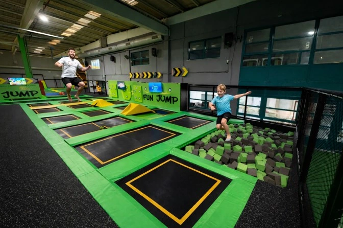 Niño y adulto saltando en trampolines en Fun Jump Valencia con zona de espuma y parque indoor de aventuras