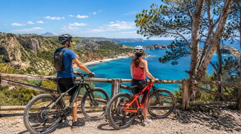 Dos turistas en una ruta con bicicleta por Jávea