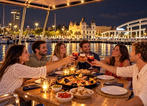 Grupo disfrutando de una cena en barco privado por la Marina de Valencia al anochecer.